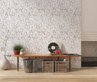 Muted grey botanical foliage wallpaper above a console with a vinyl player and baskets GD12337