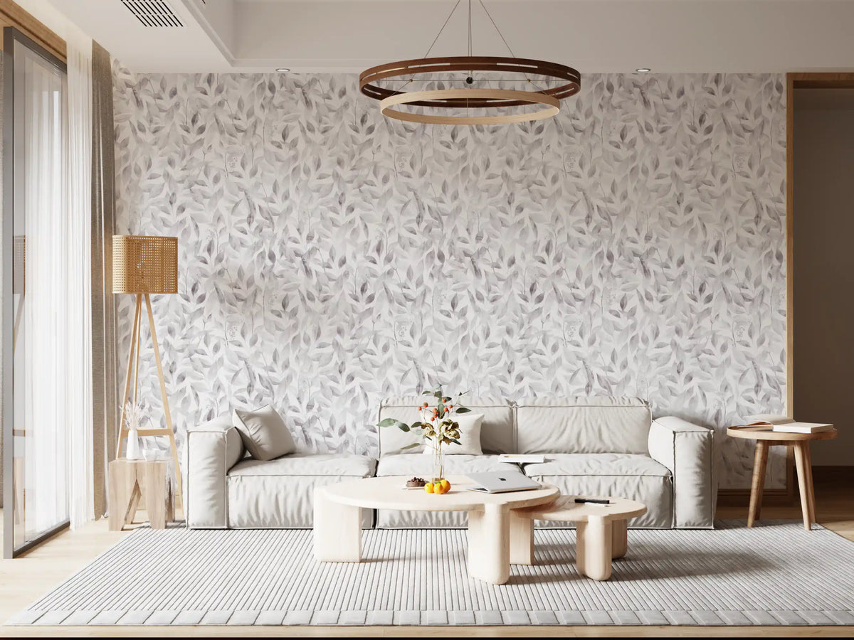 Muted grey botanical foliage wallpaper in a lounge with a grey sofa and round chandelier GD12337