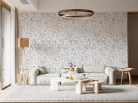 Muted grey botanical foliage wallpaper in a lounge with a grey sofa and round chandelier GD12337