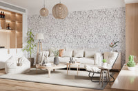 Muted grey botanical foliage wallpaper in a living room with a cream sofa and wood shelving GD12337