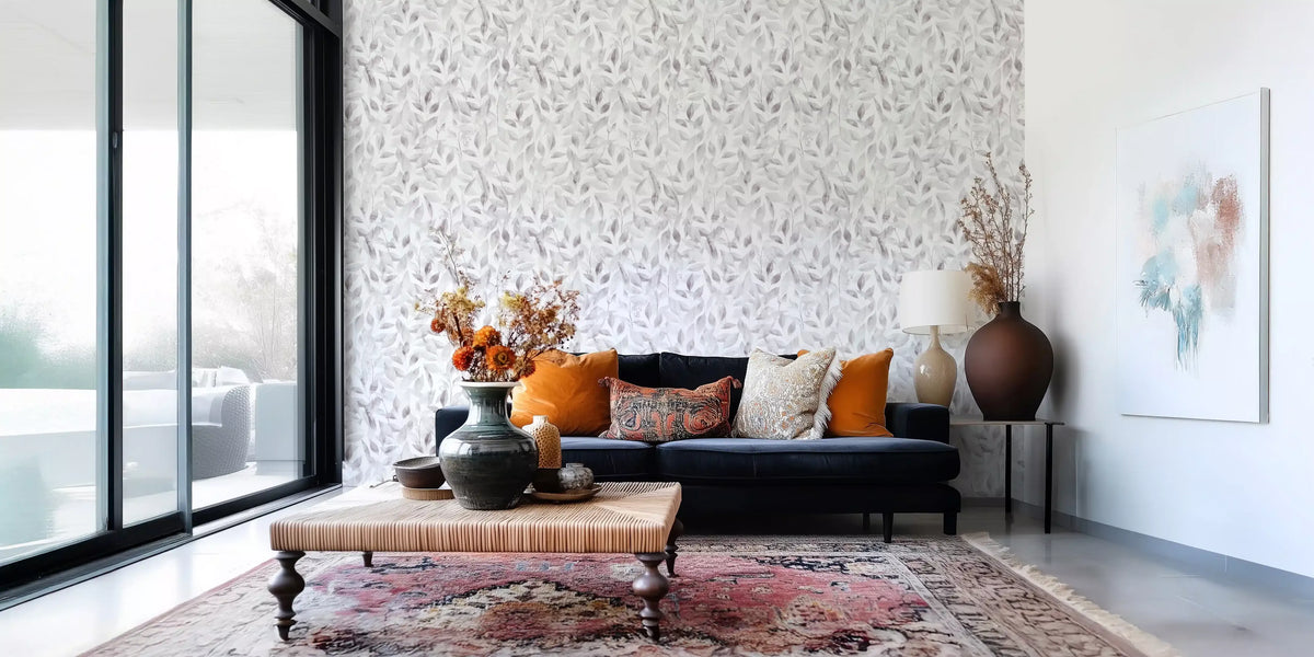 Muted grey botanical foliage wallpaper behind a navy velvet sofa with orange cushions GD12337