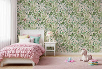 Sage floral wallpaper in a child's bedroom with a pink ruffled bed and unicorn toy GD12339