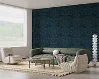 Ink leaf motif wallpaper in a living room with sage sofa and cream lounge pouffe GD12456