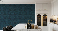 Ink leaf motif wallpaper in a white kitchen with marble island and gold tap GD12456
