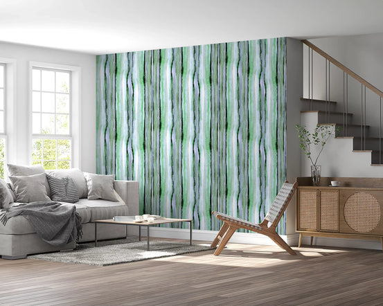 Verdant watercolor stripe wallpaper behind a grey sofa and cane lounge chair by a staircase GD12468