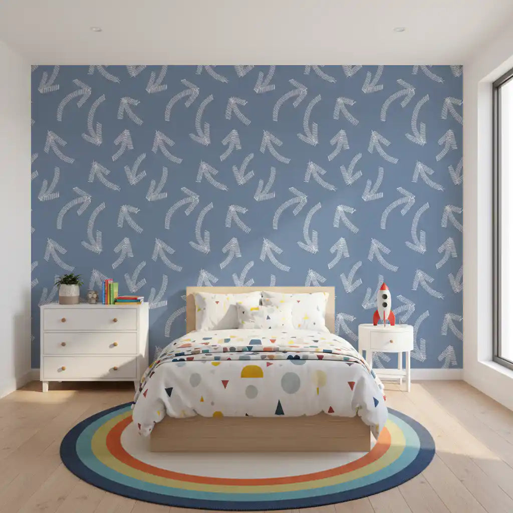 Muted blue scribble arrows wallpaper behind a child's bed with rainbow rug and dresser GD12470