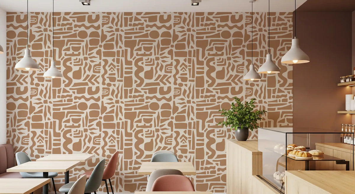 Abstract earth toned shapes wallpaper in a cafe with wood tables and pendant lights GD12478