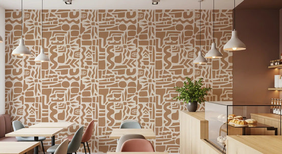 Abstract earth toned shapes wallpaper in a cafe with wood tables and pendant lights GD12478