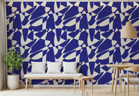 Cobalt geometric shapes wallpaper above a white cushioned bench with a potted plant GD12480