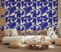 Abstract cobalt geometric wallpaper behind a cream curved sofa and wood coffee table GD12480