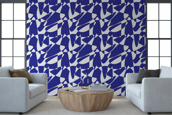 Cobalt geometric shapes wallpaper behind two pale blue armchairs and a round wood table GD12480