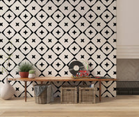 Monochrome geometric star grid wallpaper above a wooden console with plants and baskets GD12482