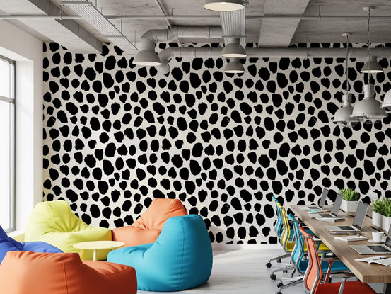 Black ink blot texture wallpaper behind colourful bean bags in an office lounge GD12487