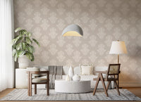 Beige sofa and wooden chairs by a monstera on cream damask scroll wallpaper GD12492