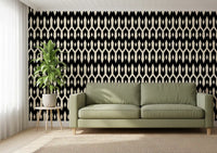 Olive green sofa and potted plant against black and cream diamond wallpaper GD12494
