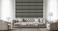 Abstract interlocking diamond motif wallpaper behind a tufted grey sofa and glass table GD12494
