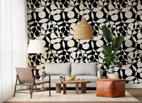 Black and white circles wallpaper behind a grey sofa with a banana plant GD12497
