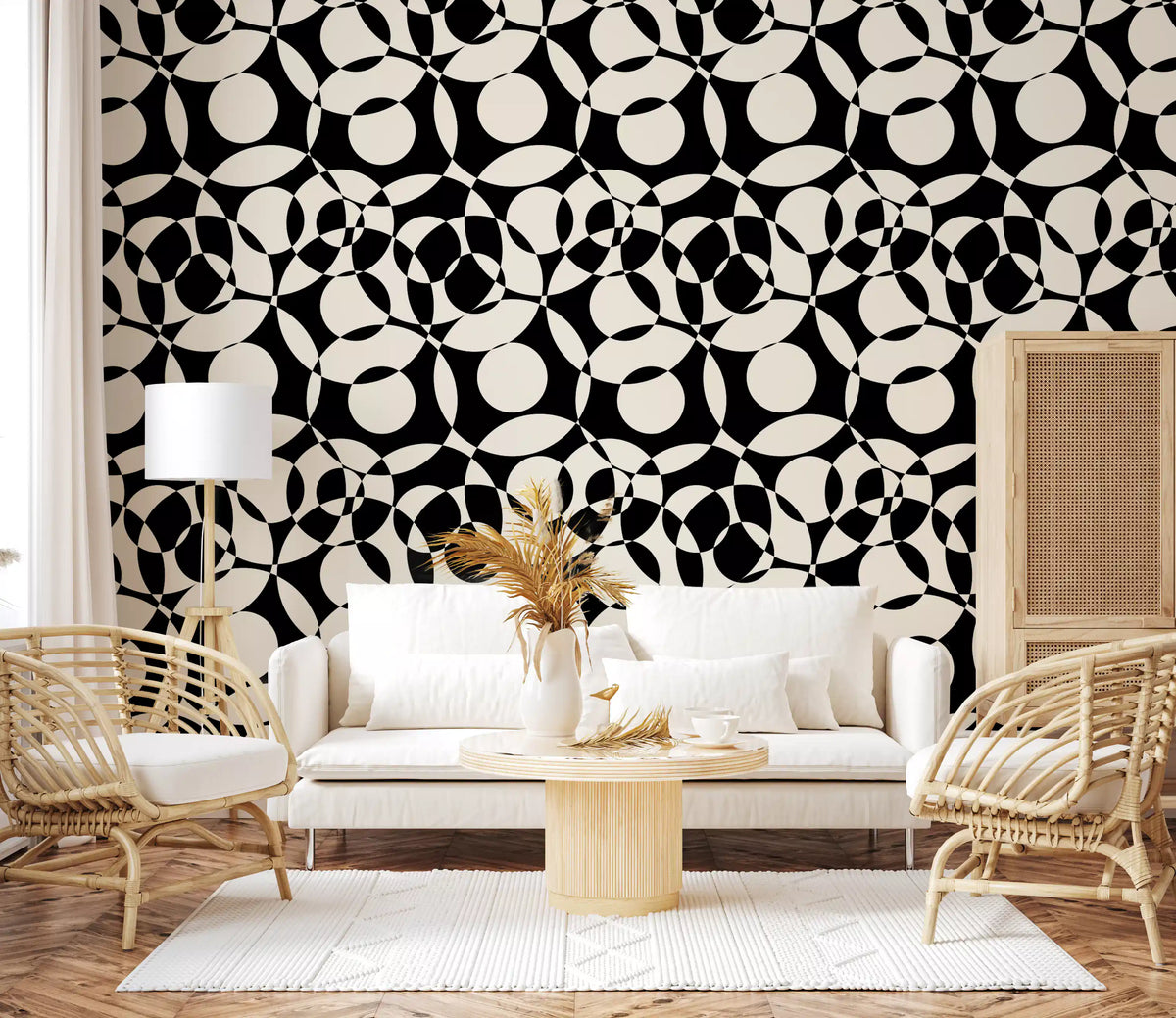 Interlocking circles wallpaper behind a white sofa with rattan chairs and pampas GD12497