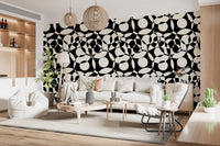 Monochrome circles wallpaper behind a beige sofa in a wood-shelved living room GD12497