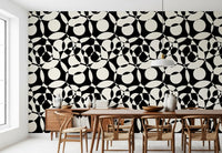 Geometric circles wallpaper behind a wood dining table with wishbone chairs GD12497