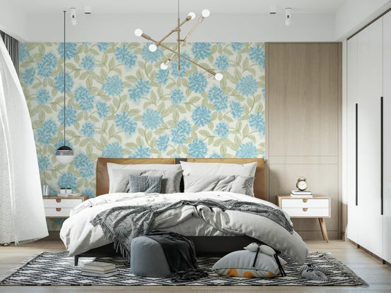Blue hydrangea wallpaper behind a grey upholstered bed with layered bedding GD12639