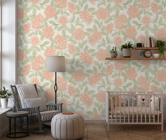 Sage and peach botanical wallpaper in a nursery with a crib and grey armchair GD12646