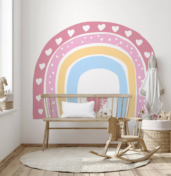 Pastel rainbow heart arch wall mural above a wooden crib in a soft nursery GD12896