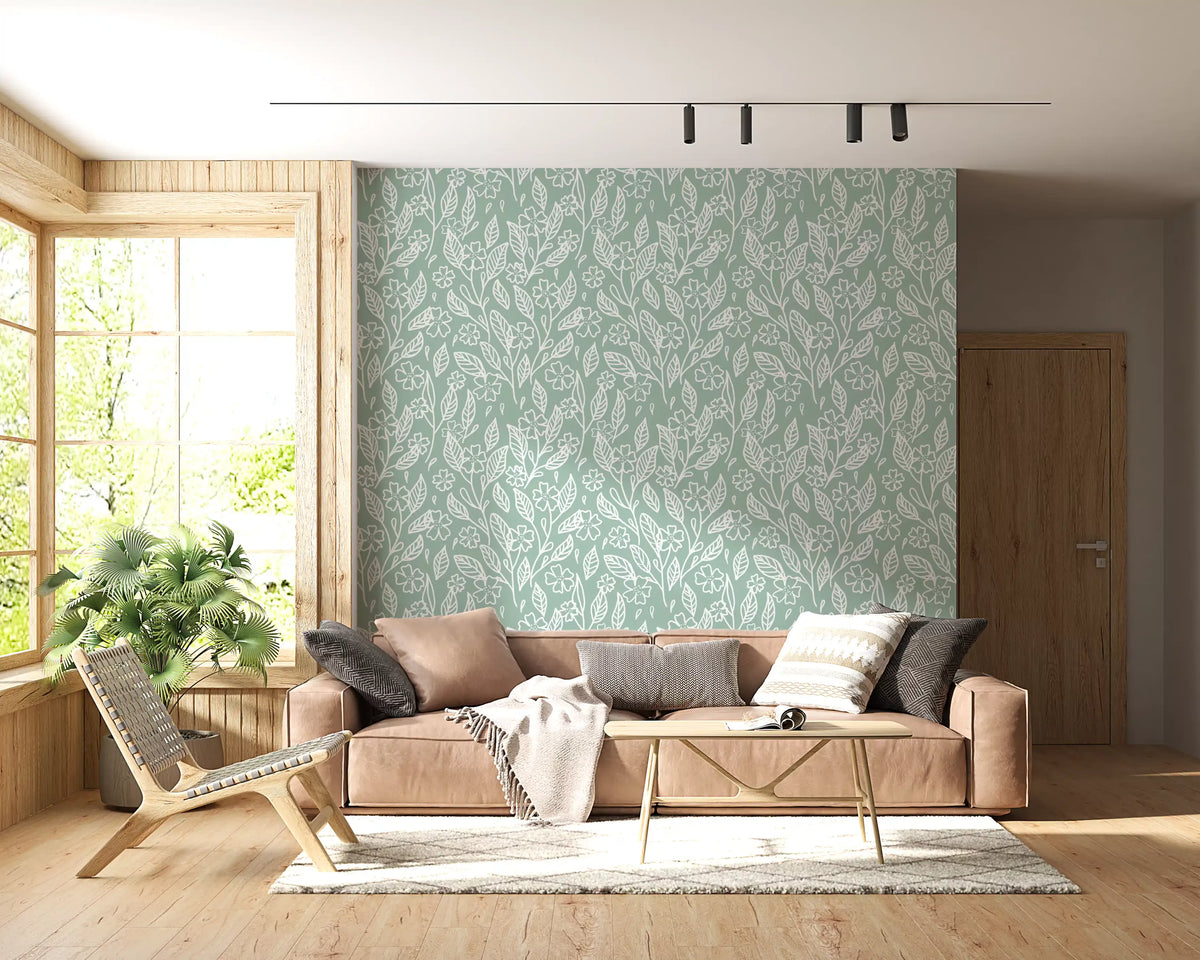 Sage green hand-drawn floral line art wallpaper in a living room with a tan sofa GD12983