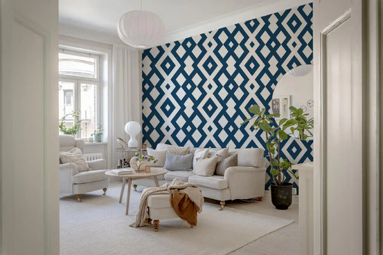 Blue and white geometric wallpaper seen through a doorway into a bright living room with cream sofa GD13518