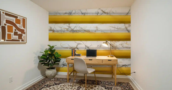 Marble wallpaper mural in a home office with a wood desk, laptop, lamp and patterned rug GD13914