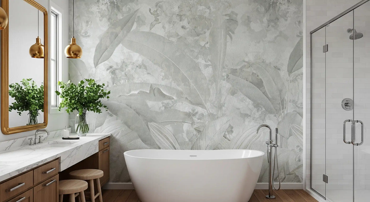 Tropical wallpaper in soft gray behind a freestanding tub, gold framed mirror and glass shower GD13955