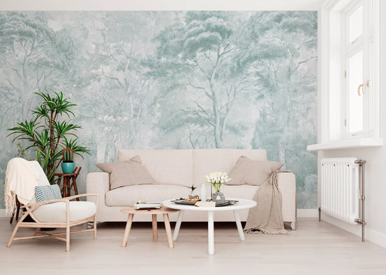 Sage misty forest wallpaper behind a cream sofa, round white coffee table and potted palm GD13979