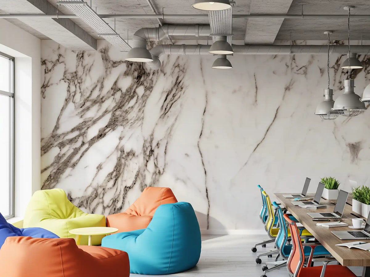 White marble wallpaper in an open office with colorful bean bags and long desks GD14122