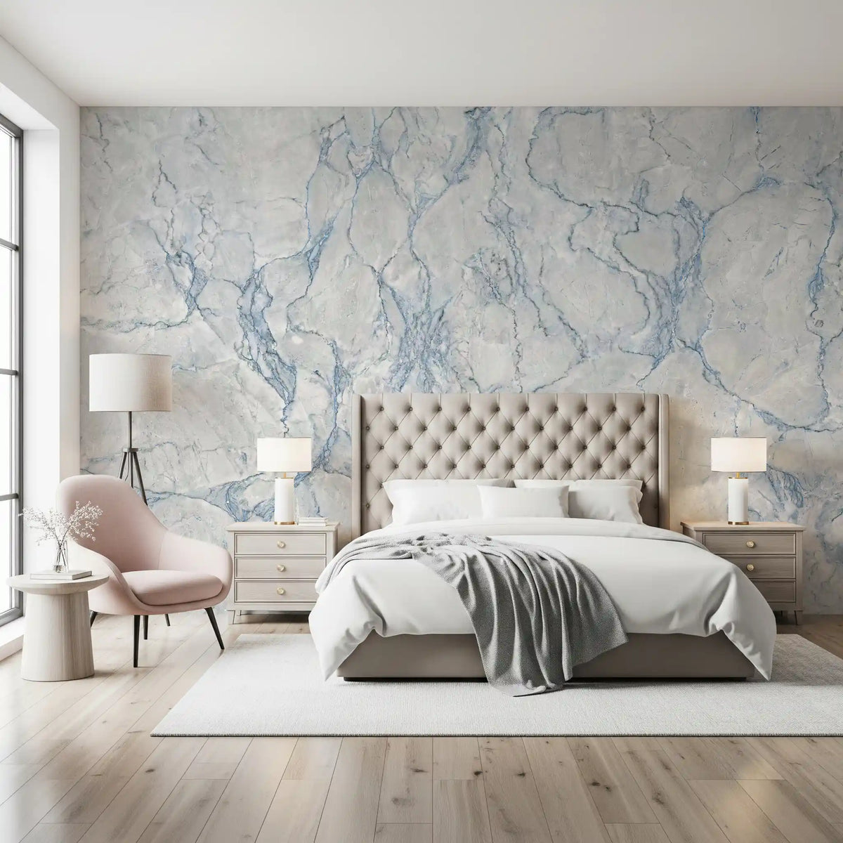 Blue veined marble wallpaper behind a tufted beige bed with a blush pink lounge chair GD14155