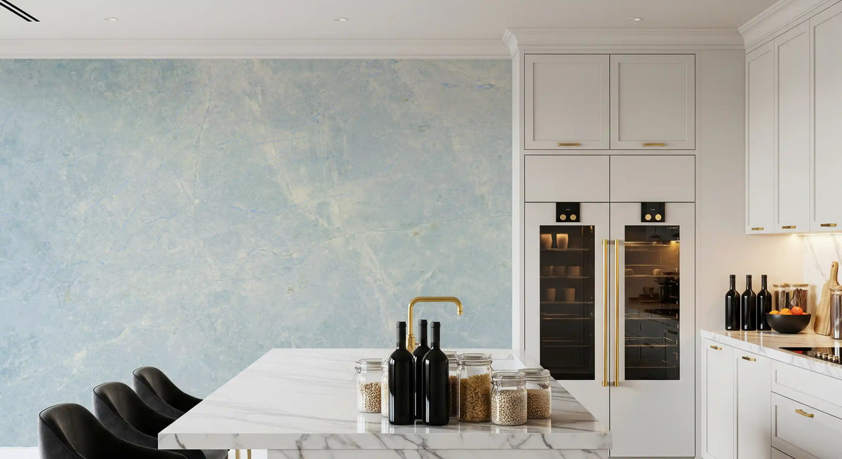 White kitchen with marble island, wine fridge and bottles beside blue marble wallpaper GD14187