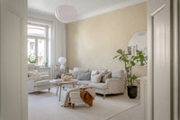 Classic living room with gray sofas seen through a doorway on a cream stone mural GD14189