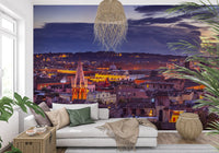 White sofa with green cushions and woven pendant against a purple city sky GD14206