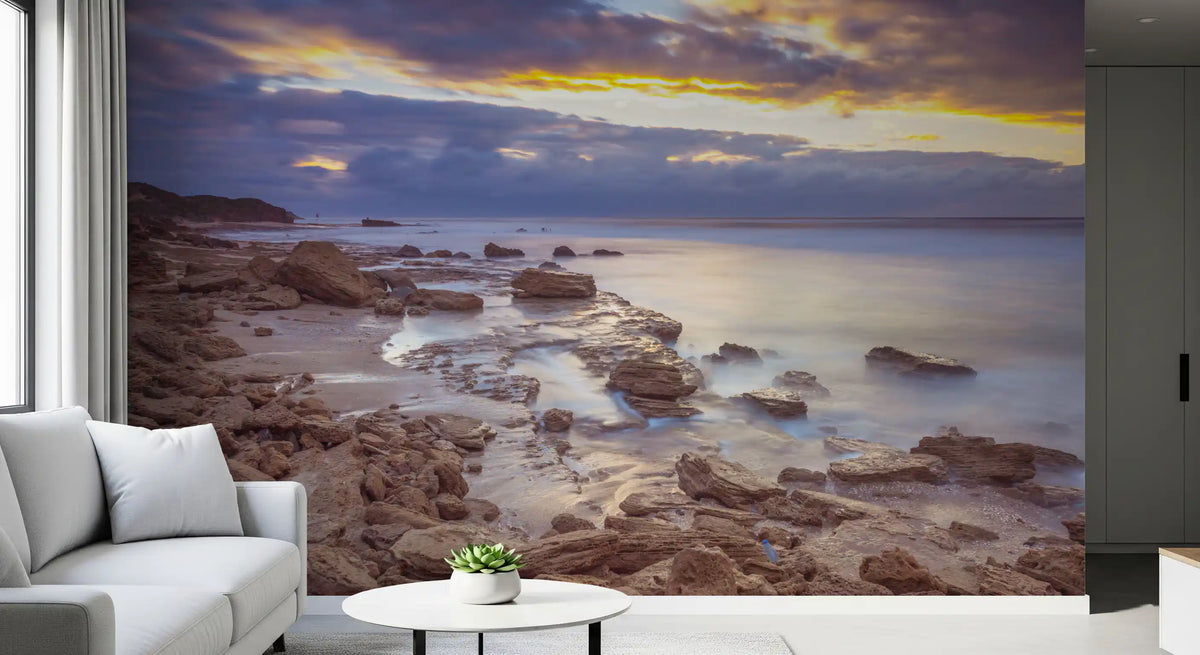 Beach wallpaper beside a gray sofa and round white side table with small plant GD14207