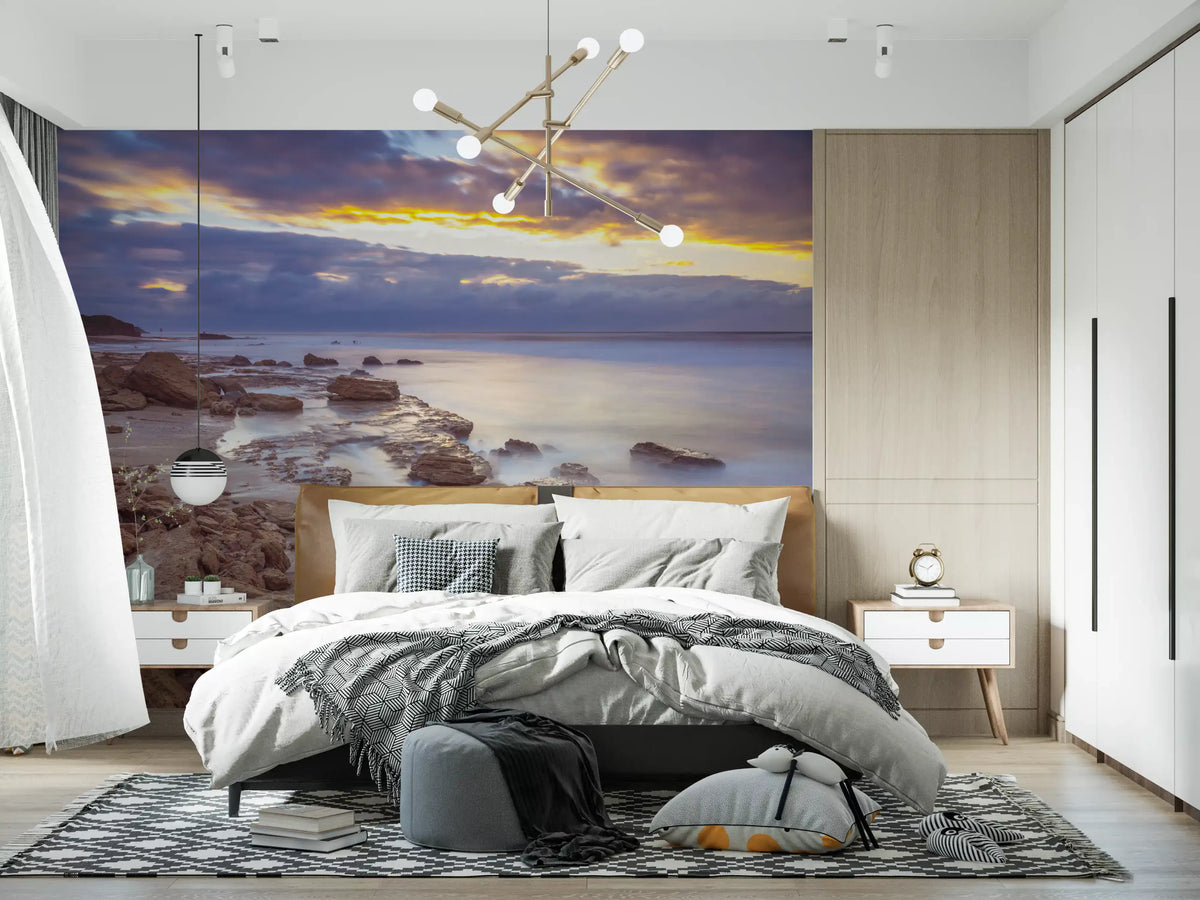 Beach wallpaper in a bedroom with wood headboard, gray bedding and chandelier GD14207
