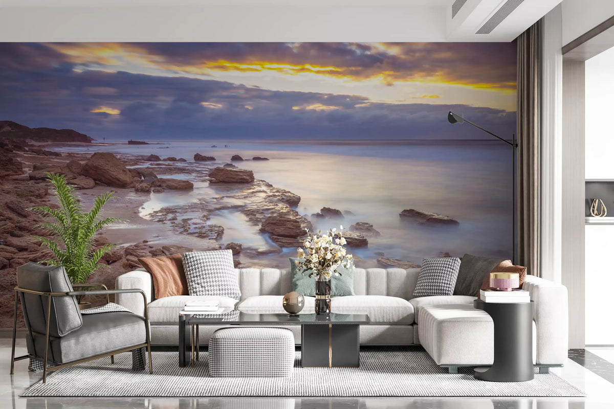Beach wallpaper behind a cream tufted sectional, gray armchair and flowers GD14207
