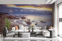 Beach wallpaper behind a cream tufted sectional, gray armchair and flowers GD14207