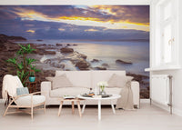 Cream sofa, rattan armchair and round white tables before a twilight sea mural GD14207
