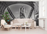 London wallpaper behind a cream sofa, rattan armchair and round white tables GD14209