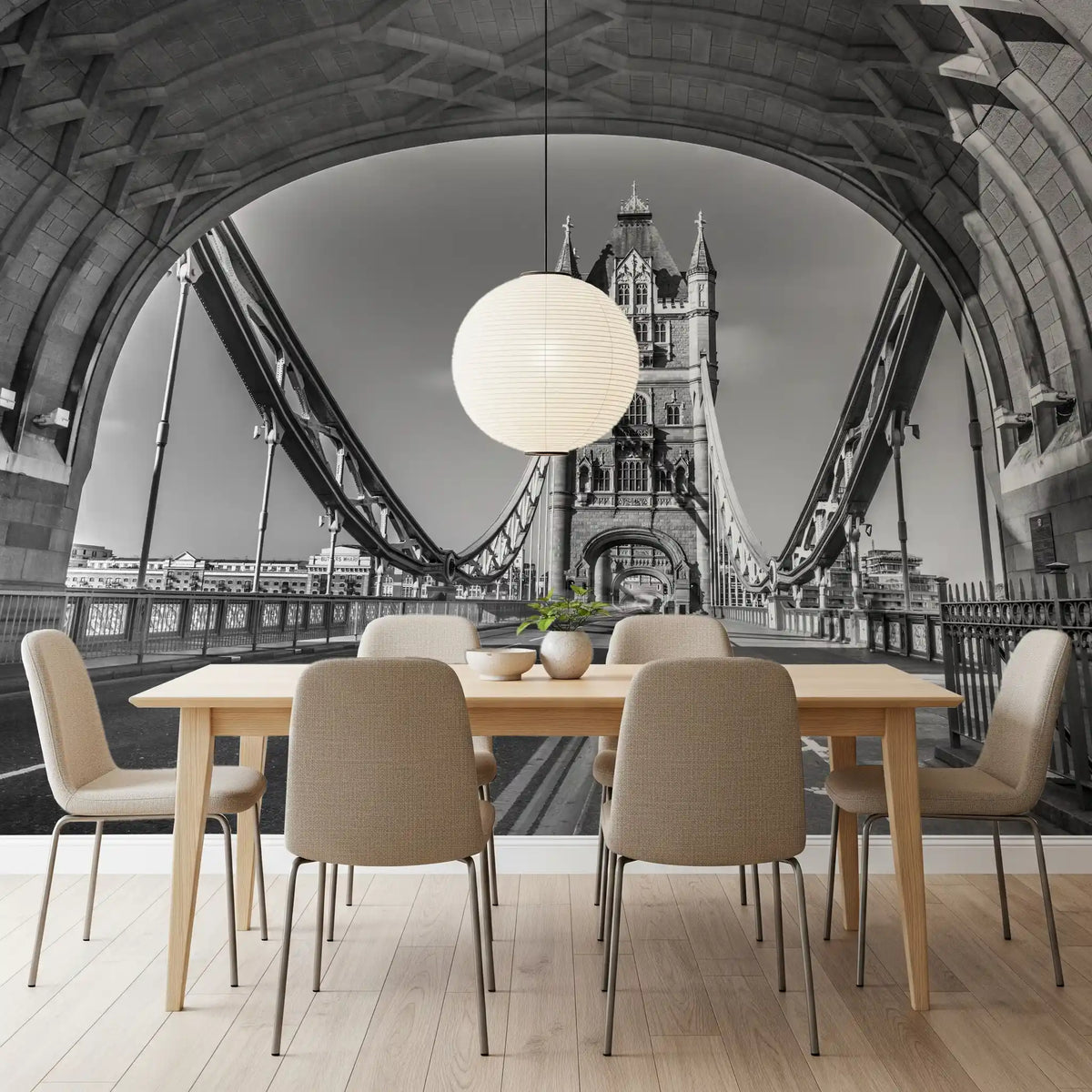 Dining table with taupe chairs and paper globe pendant before a black and white arch GD14209