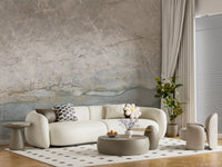 Marble wallpaper behind a cream curved sofa and round pouf on a dotted rug GD14215