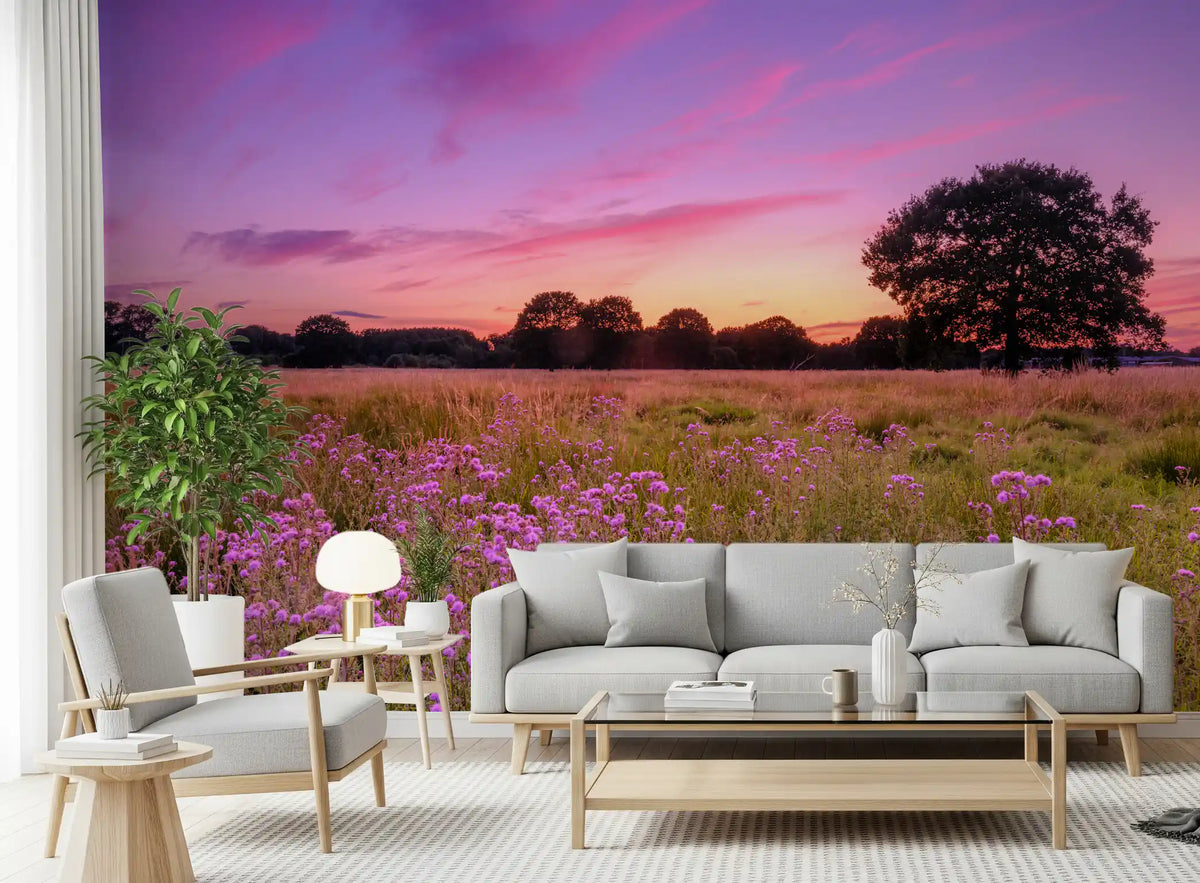 Living room with light gray sofa, glass coffee table and white armchair on a sunset meadow mural GD14217