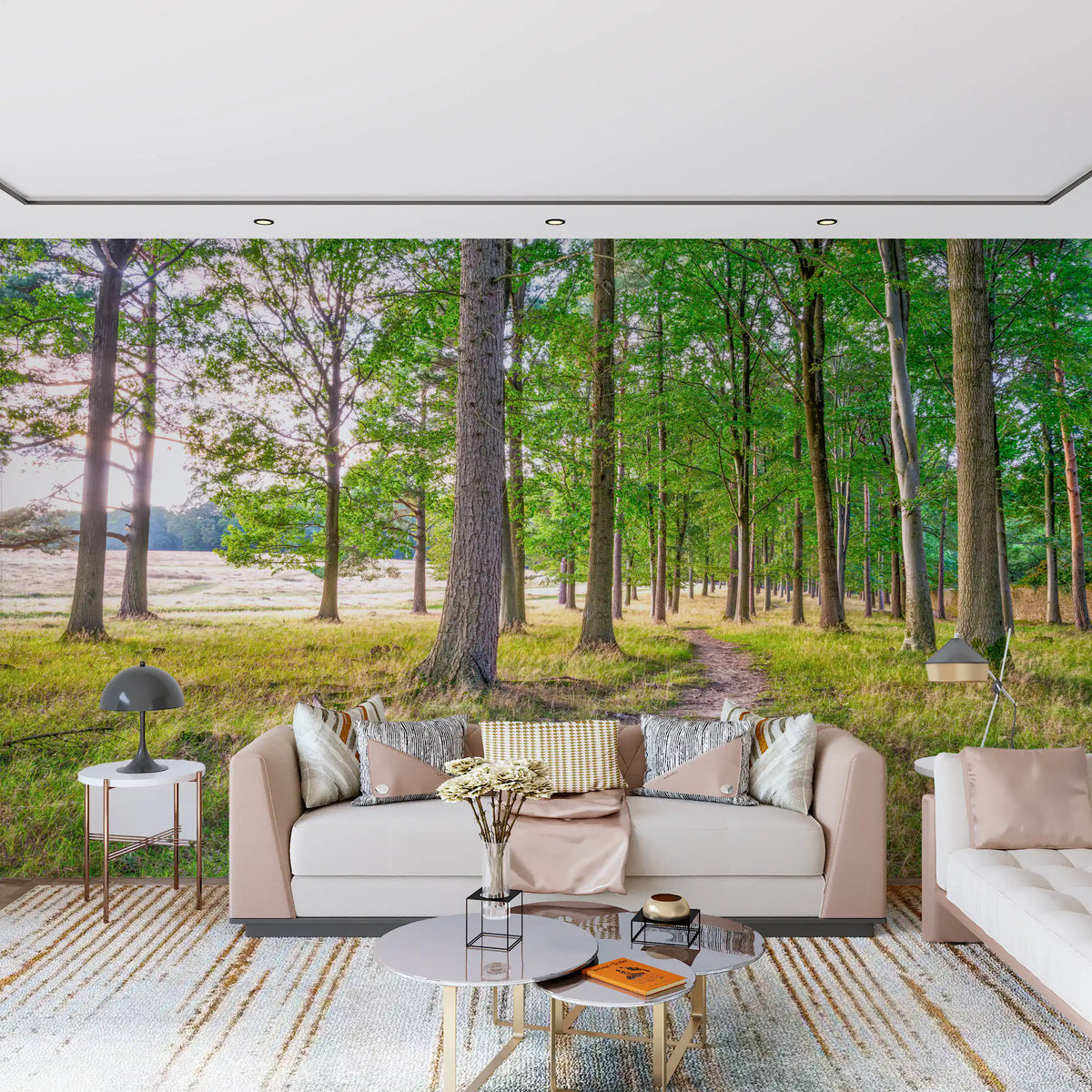 Blush pink sofa and round glass coffee table in front of a green forest path wall mural GD14219
