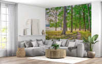 Gray sectional sofa and round wood coffee table in a white room with a woodland trail mural GD14219