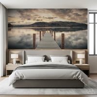 Bedroom with gray upholstered bed and white lamps against lake wallpaper of calm water GD14220
