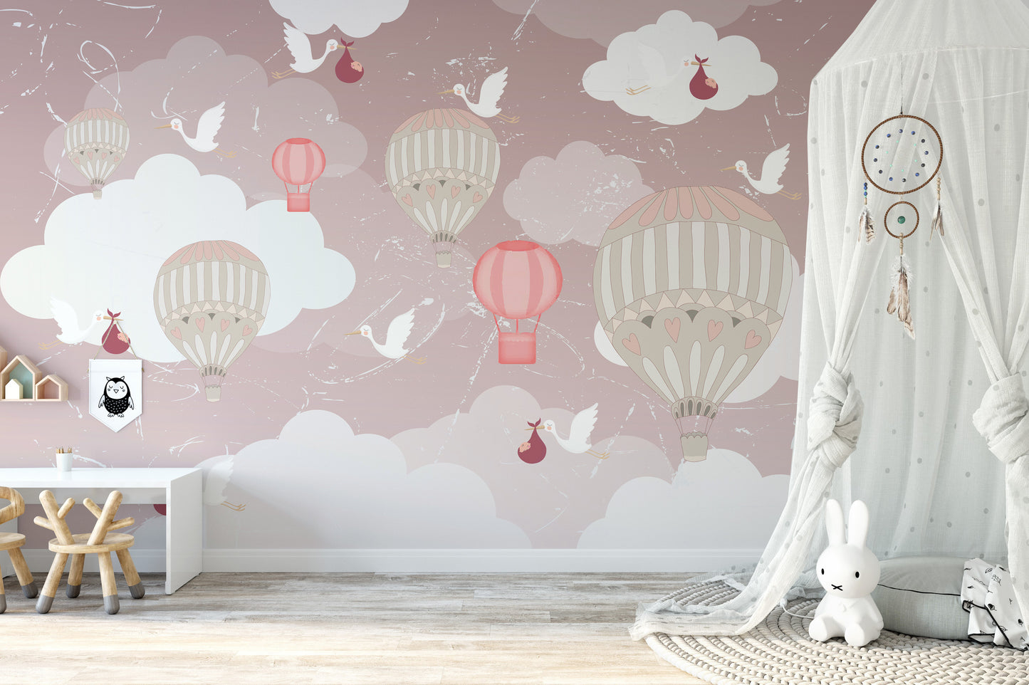 3D Hot Air Balloon wallpaper mural in soft pink with balloons and storks behind a white play desk and bunny lamp
